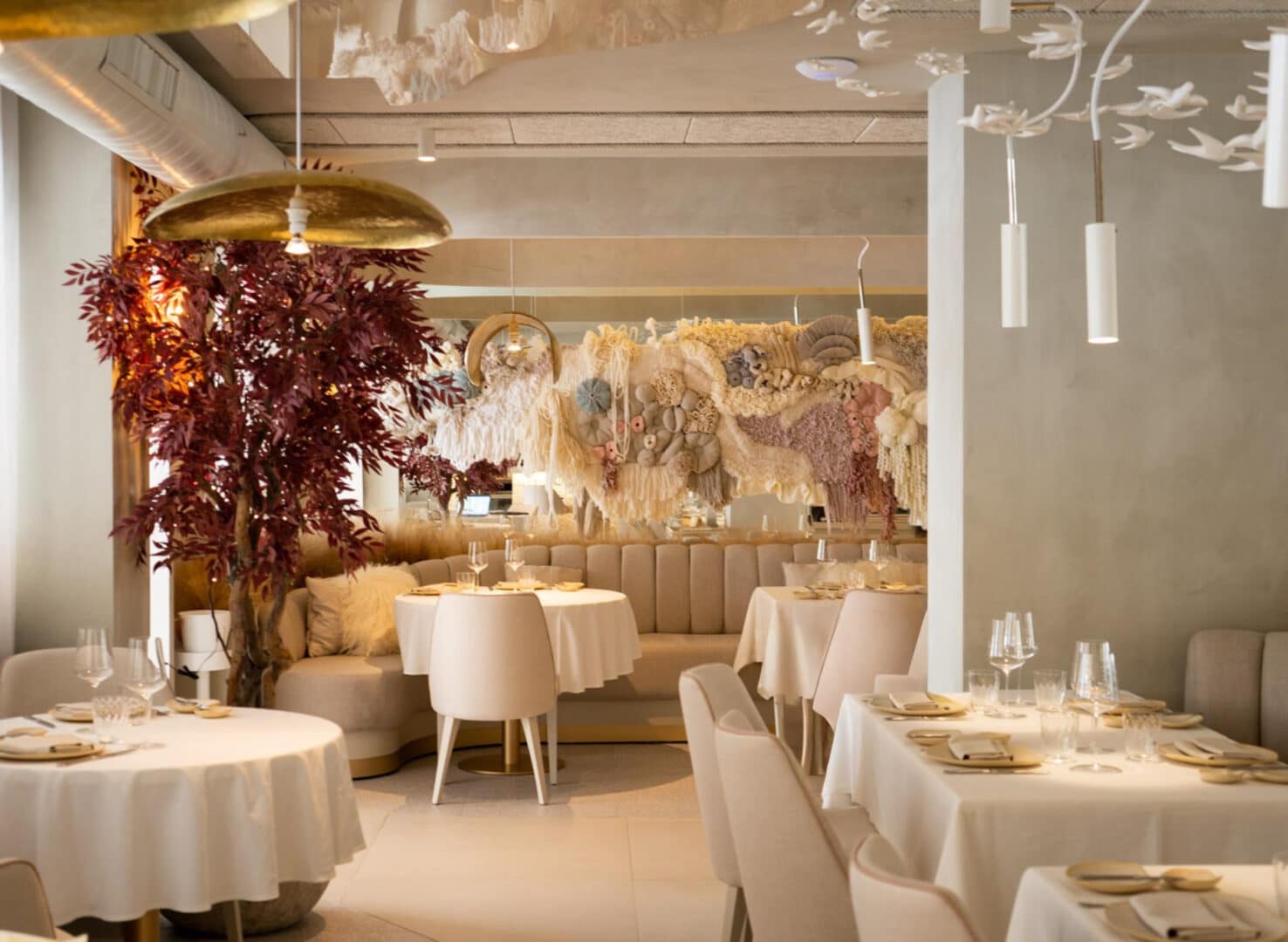 Interior elegante del restaurante Areia Marbella con mesas vestidas, iluminación cálida y atmósfera elegante en el centro de Marbella